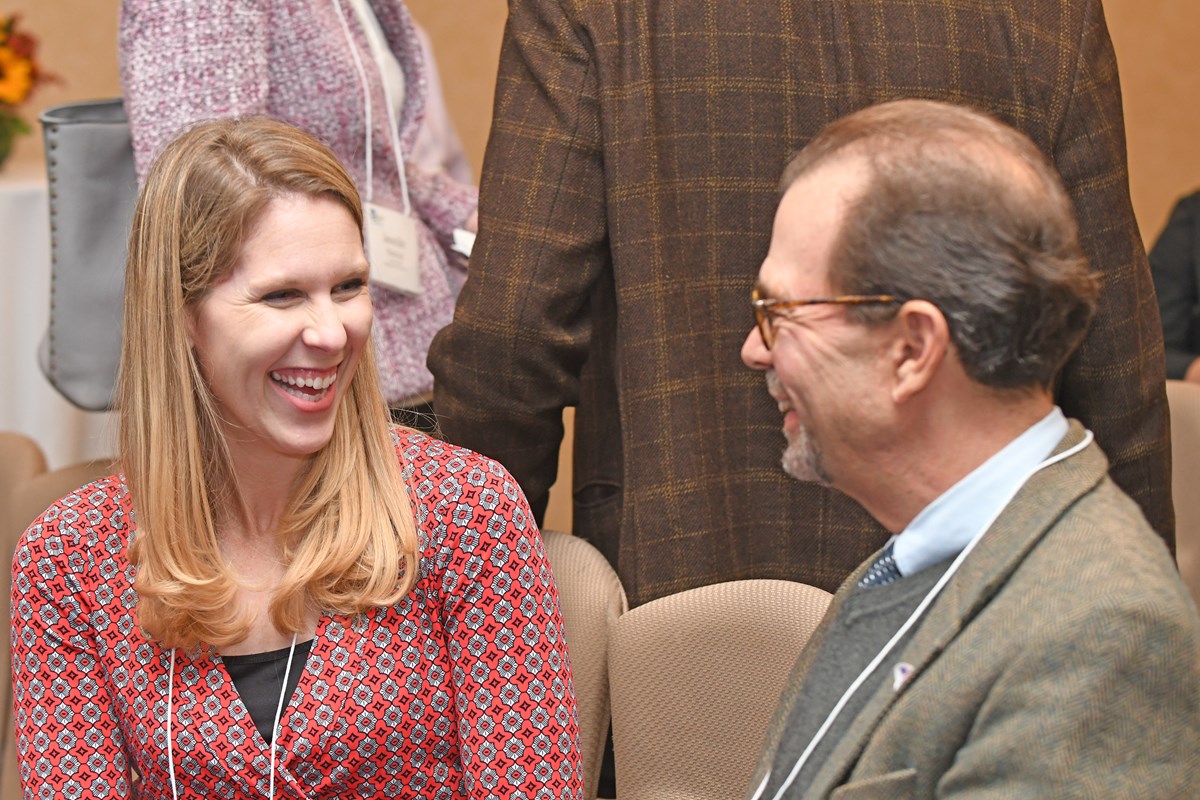 Two faculty members smiling and networking