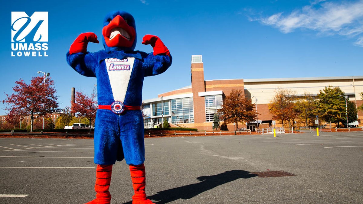 Zoom background where Rowdy the River Hawk is doing a strong man pose outside of the Tsongas Center with UMass Lowell logo in corner.