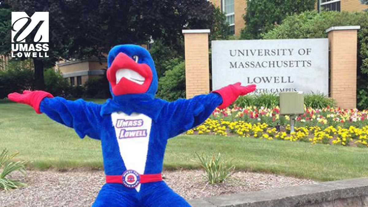 Zoom background of Rowdy the River Hawk posing in front of the North Campus sign with UMass Lowell logo in the corner.