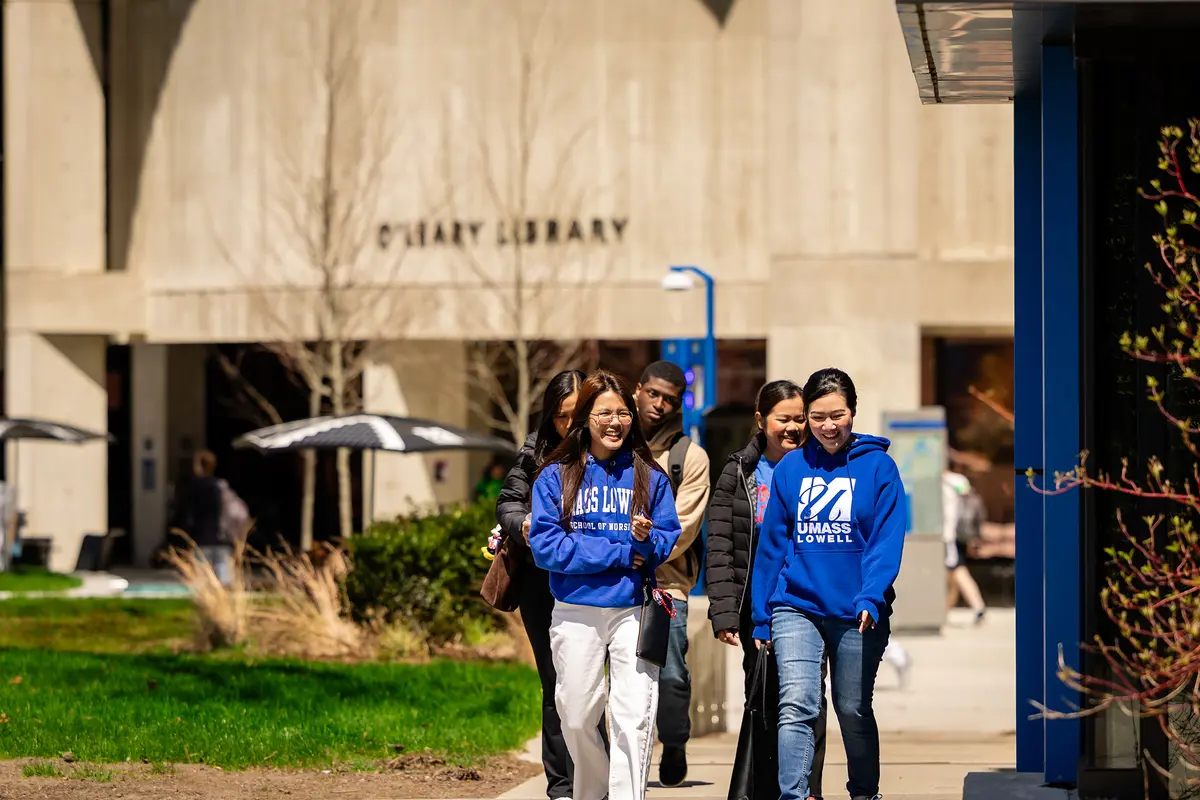 UMass Lowell students walk on South Campus in front of O'Leary Library