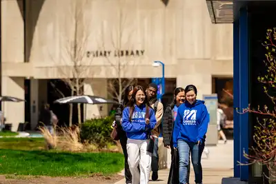 UMass Lowell students walk on South Campus in front of O'Leary Library