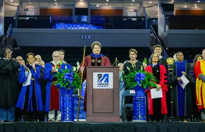 The Provost opens Convocation ceremonies on stage with faculty and staff.