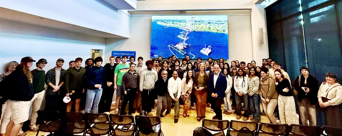 Speakers centered surrounded by student attendees posing for a group picture.