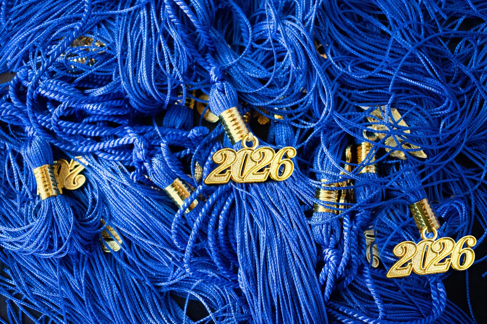 Pile of blue tassels with gold 2026 charms