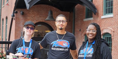 Three members of Residence Life outside River Hawk Village 