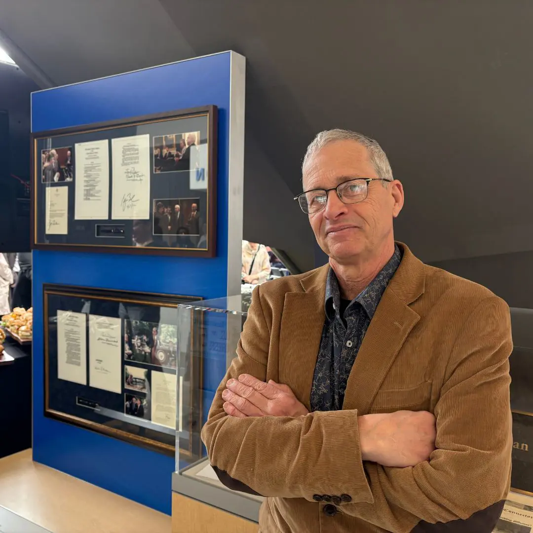 Head Archivist Tony Sampas next to a display of items at the new Meehan Student Center.