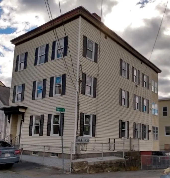 Exterior three story home with flat roof and side entrance.