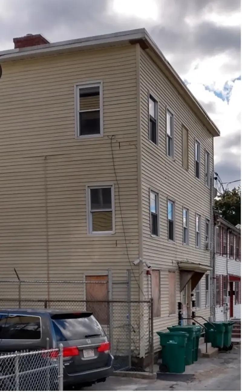Side view of exterior of three story, flat roofed home.