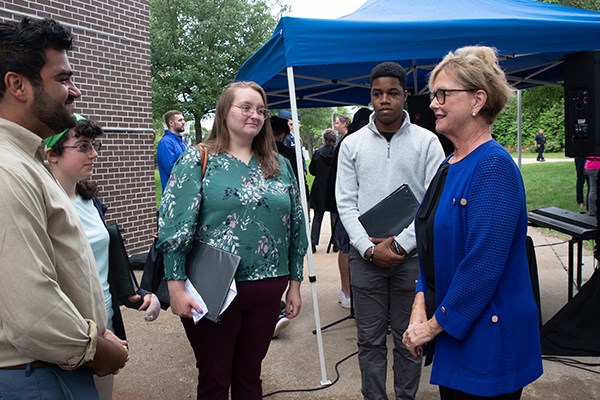 Chancellor Moloney talks to a group of students outside