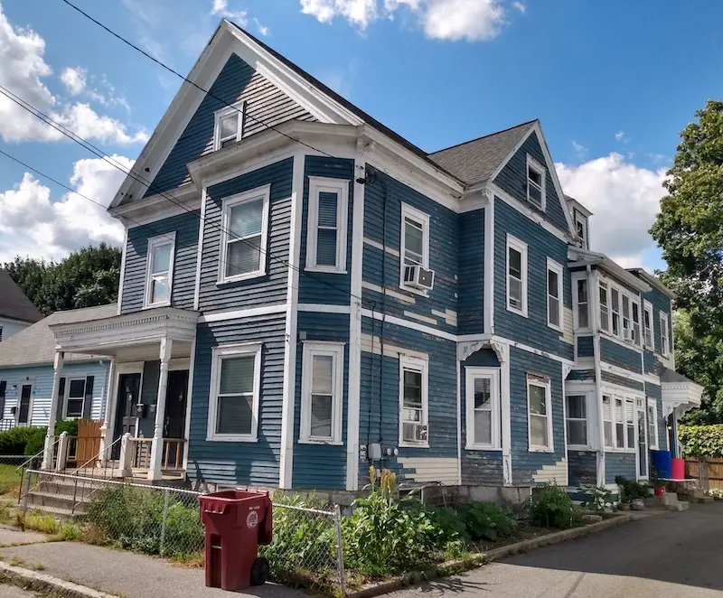 Two-story, two-family with front landing in vaguely Italianate style.