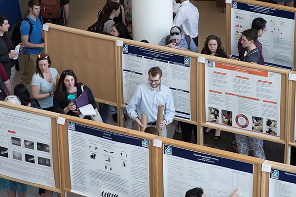 Students look at research posters at University Crossing