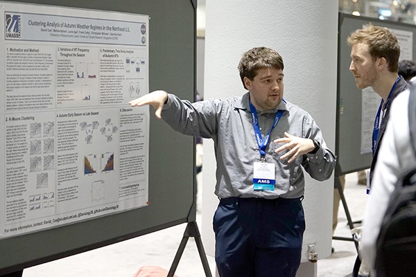 Ph.D. student David Coe explains his research to a conference-goer