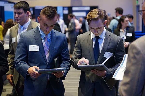 Two students enter information on tablets at the accounting career fair