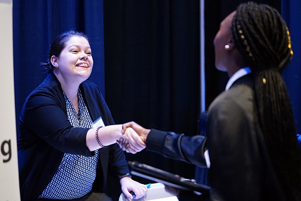 A recruiter shakes hands with a student at the accounting career fair