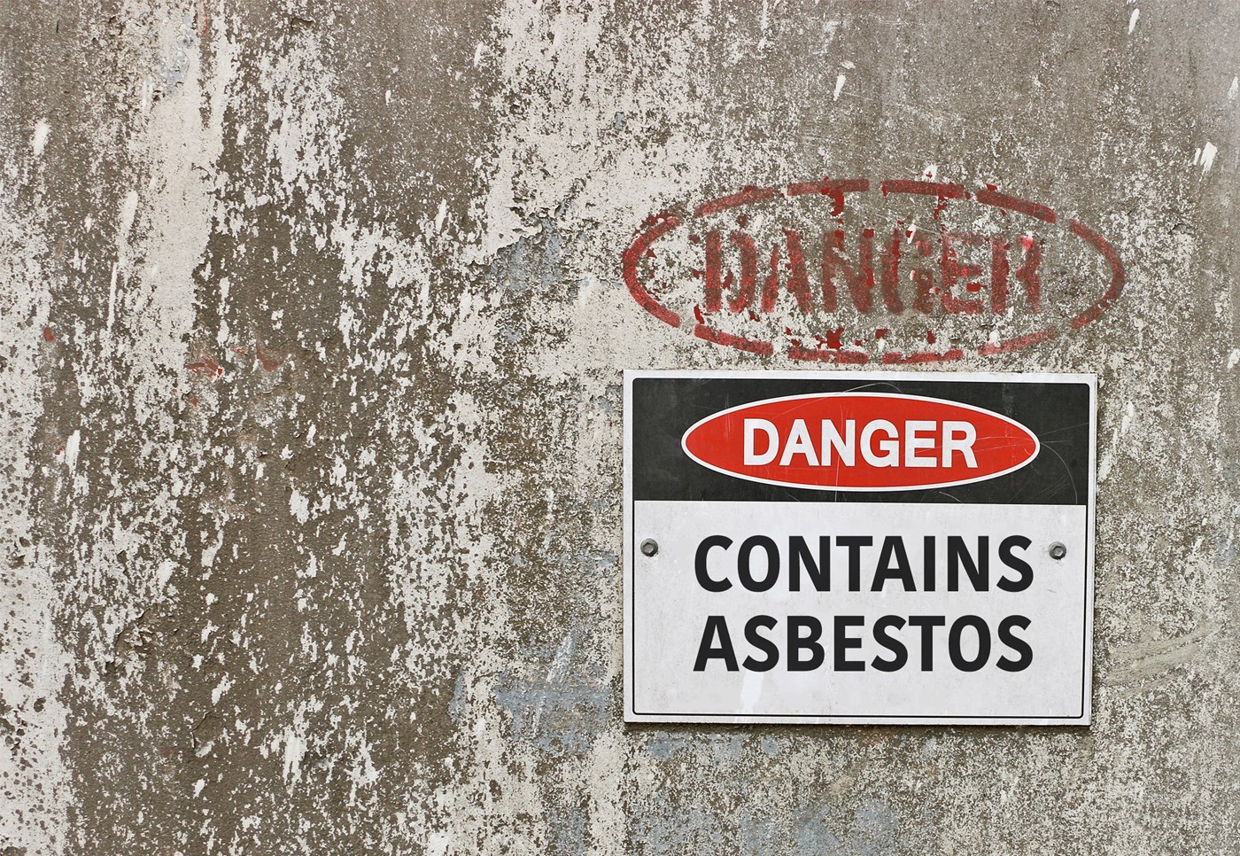 Danger Contains Asbestos sign on concrete wall