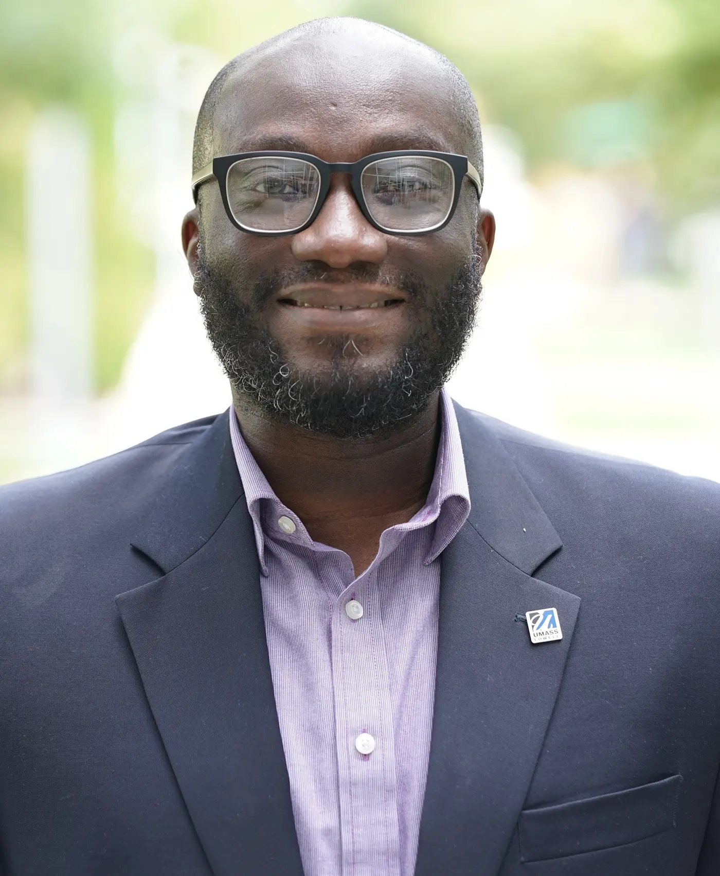 Benjamin Adoo wearing a UMass Lowell pin.
