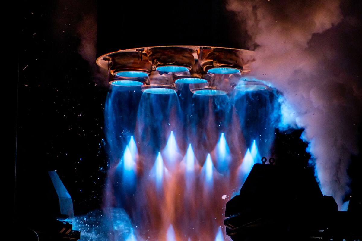 Rocket engine being launched and the exhaust emitting colorful blue flames. 