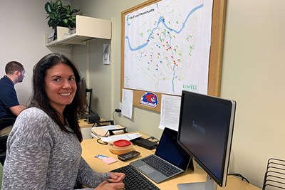 UML Nutritional Sciences Assoc. Prof. Sabrina Noel works in the Health Assessment Lab near a map of all the Lowell parks evaluated for an Age-Friendly Lowell study.