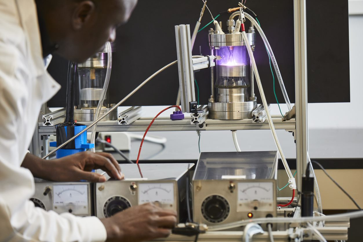 Graduate Student Benard Tabu operates a low-temperature plasma reaction in the Perry Energy Lab