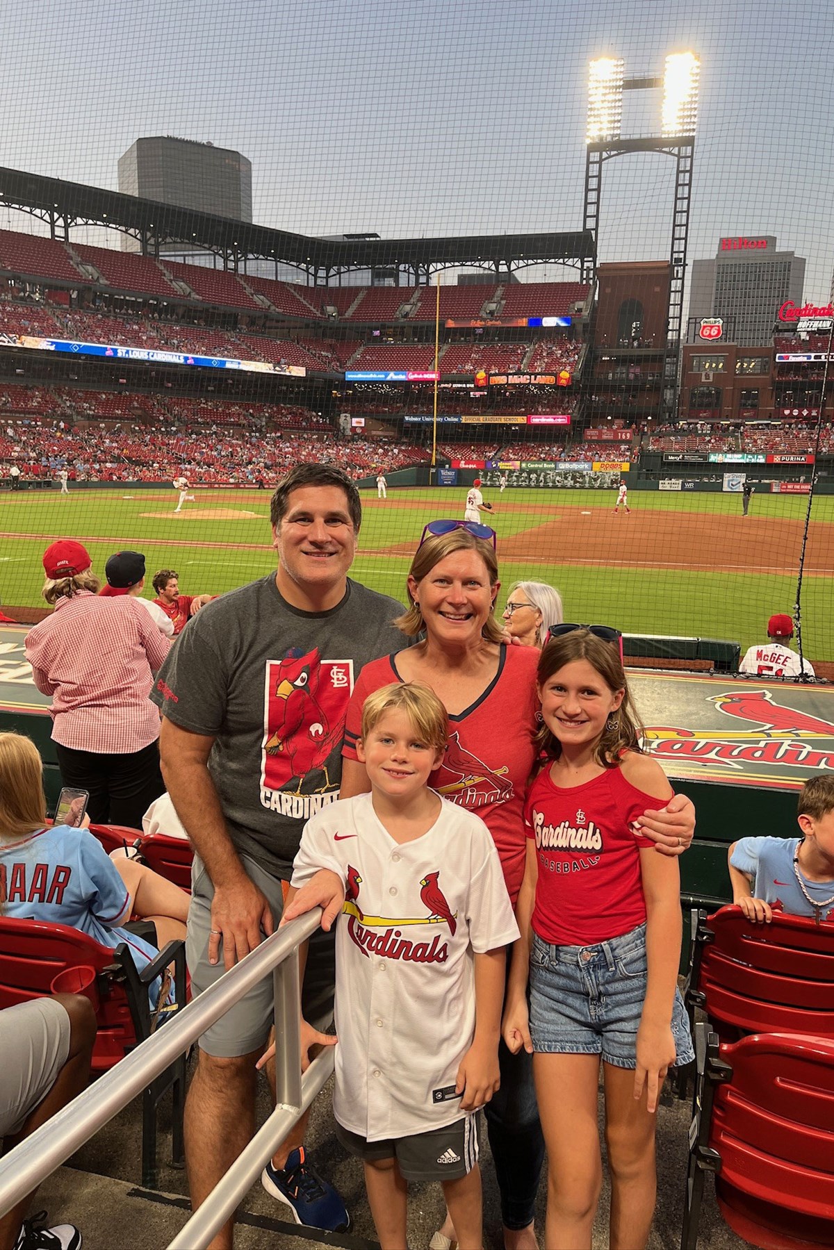 Becky O'Hara and her family at a St. Louis Cardinals baseball game in the evening. 