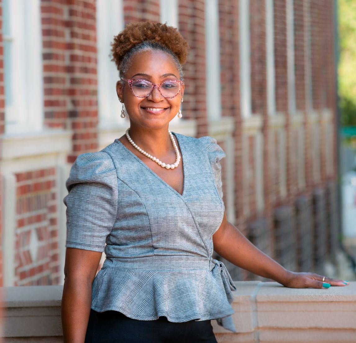 Andrea S. Boyles standing outside school building. Boyles is author of UC Press books, You Can’t Stop the Revolution: Community Disorder and Social Ties in Post-Ferguson America (2019) and Race, Place, and Suburban Policing: Too Close for Comfort (2015).  