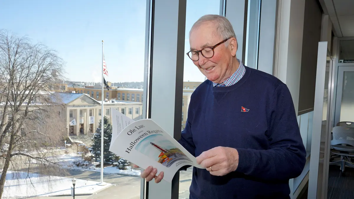 Andrew Rodger reading in front of a window.