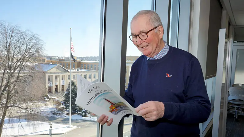 Andrew Rodger reading in front of a window.