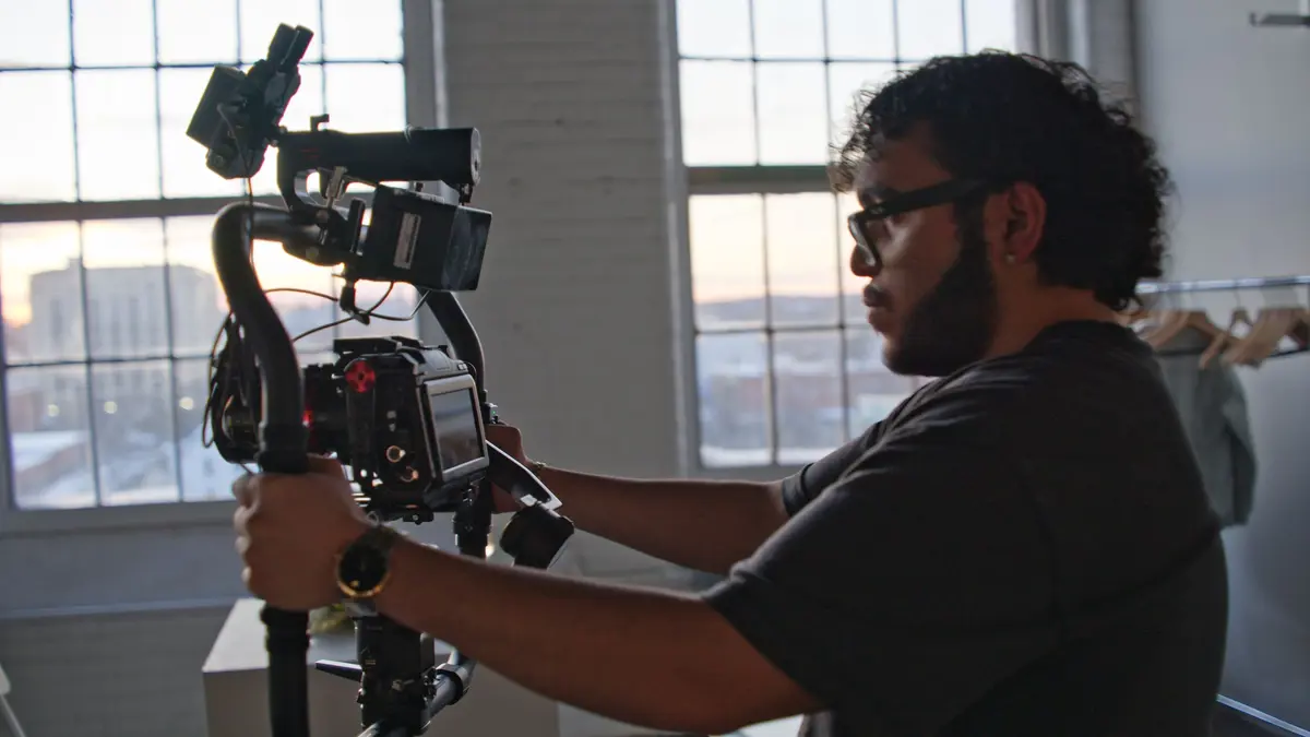 Angel Disla holding a camera.