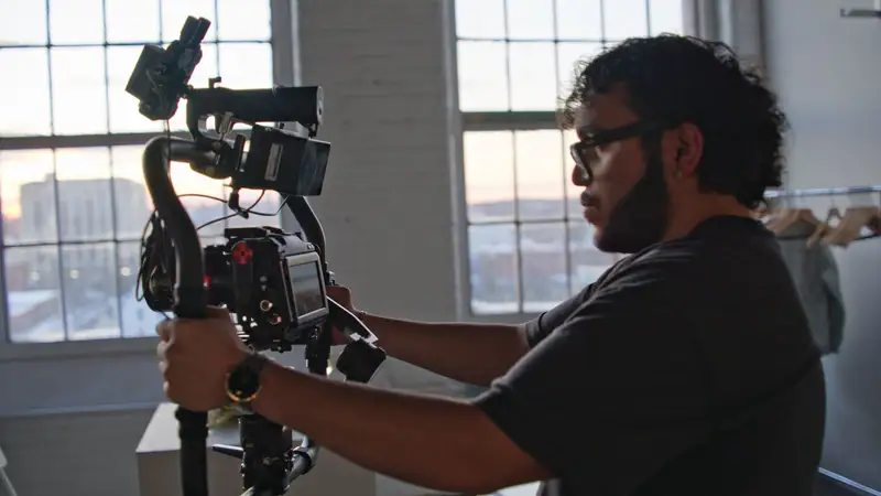 Angel Disla holding a camera.