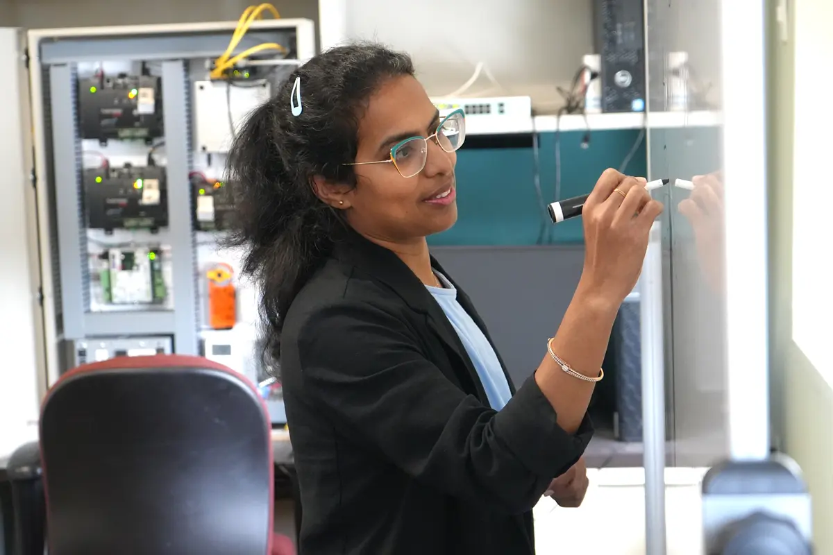 Anitha Gollamudi writes on a whiteboard.