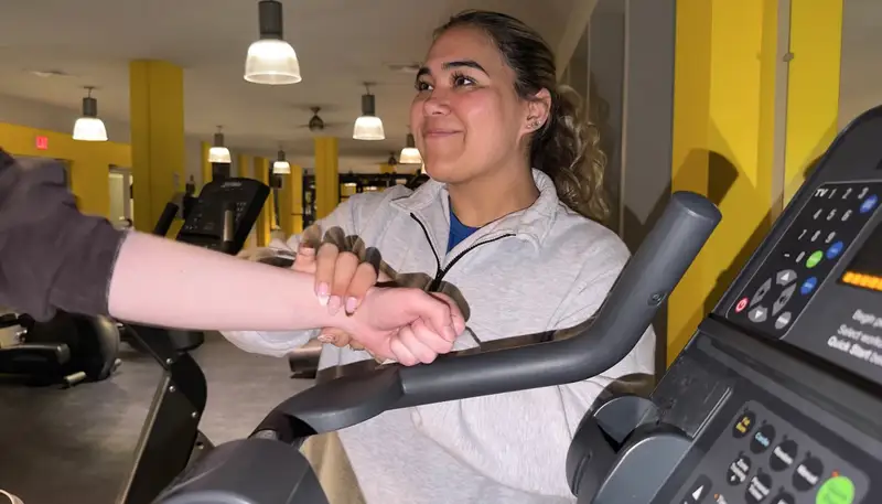 UMass Lowell student Anna Tang taking measurements on a person's arm.