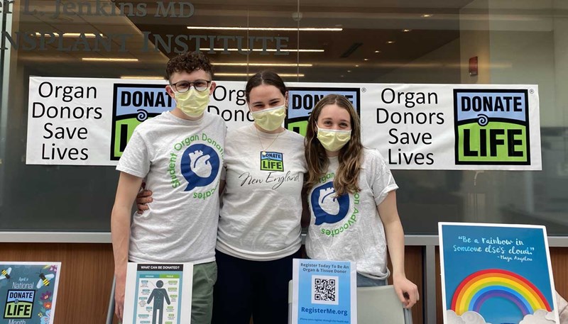 Anthony Milisci stands with two other students behind a table promoting Student Organ Donation Advocates, a student-run initiative to spark dialogue about organ donation