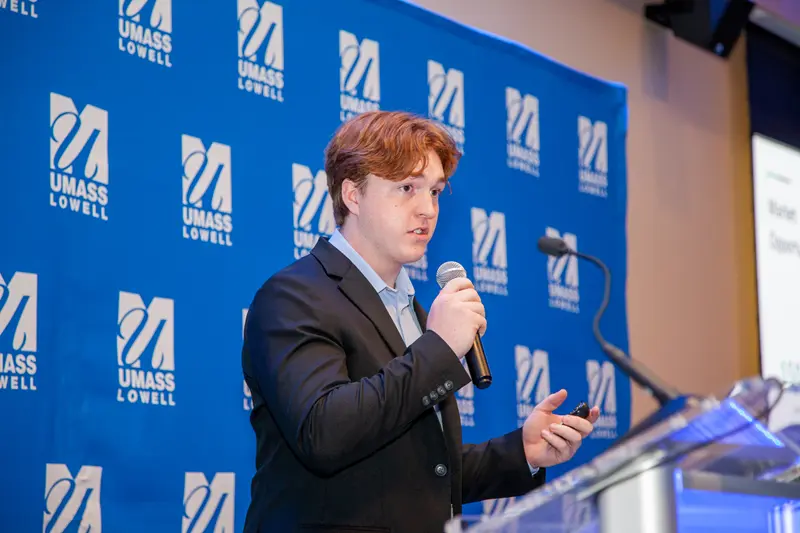 Team App Track presenting their DifferenceMaker idea as they’re holding a microphone.