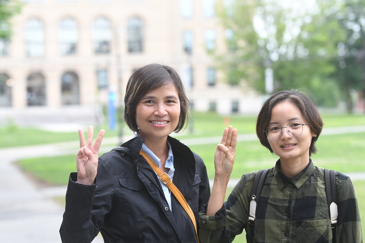 UMass Lowell Political Science Prof. Ardeth Thawnghmung and Ph.D. student Naw Moo Moo Paw give the three-finger that signals opposition to the military coup in Myanmar