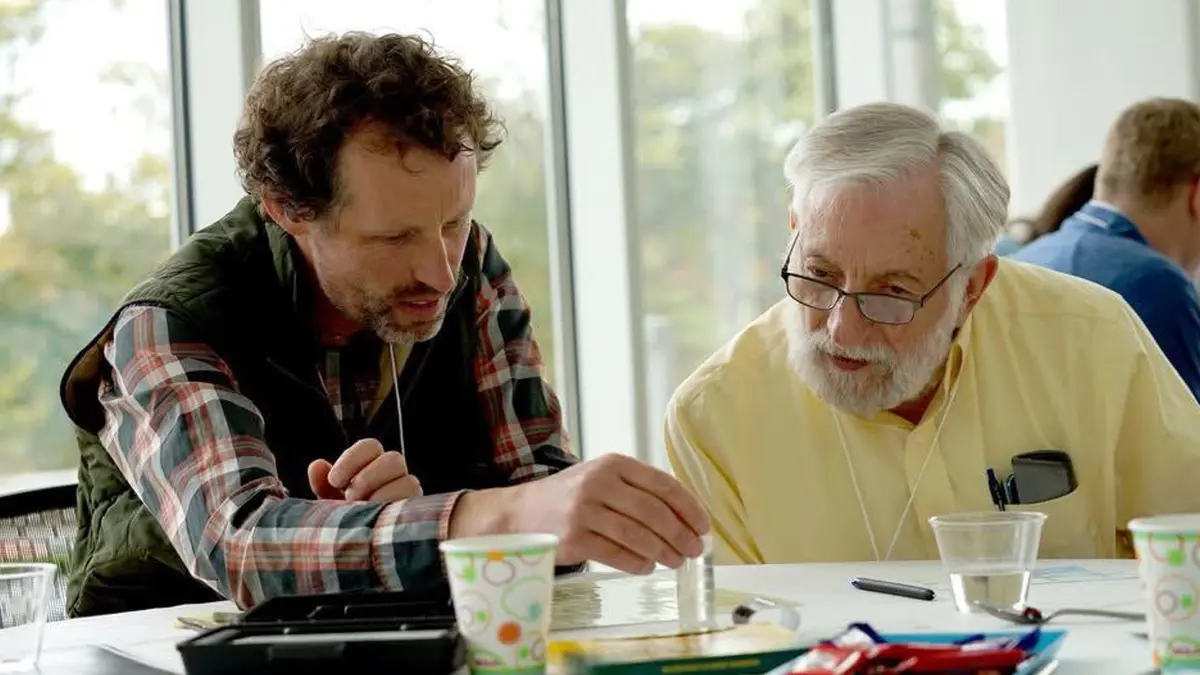 Art Mittler and fellow professor look at paper on table