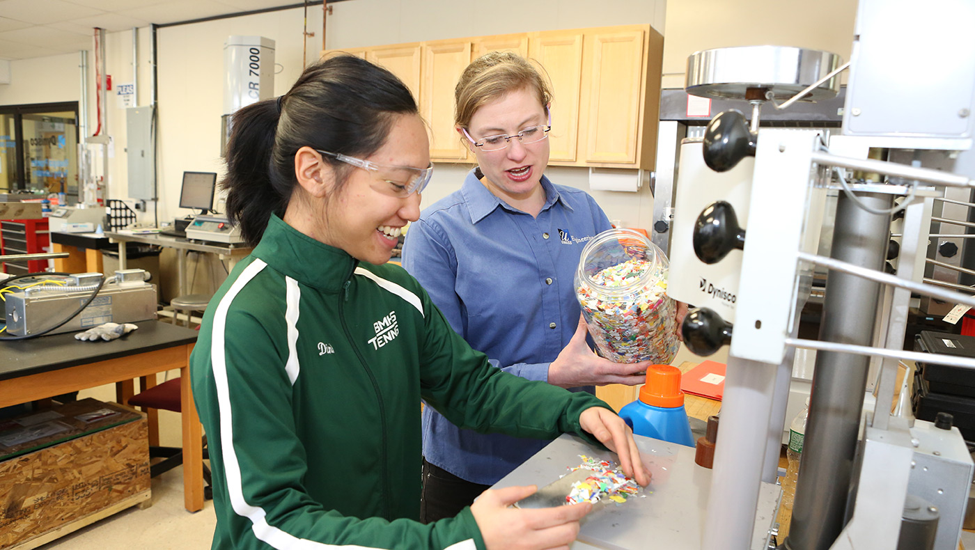 Asst. Prof. Meg Sobkowicz-Kline demonstrating things to a female student in the plastics recycling lab.
