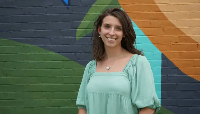 Autumn Kleiner poses in front of a mural