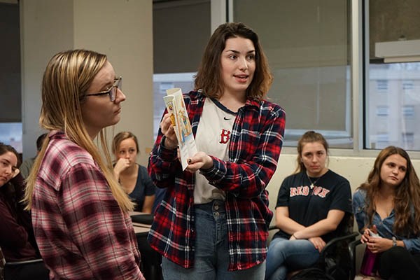 Undergraduate education major Sarah Robinson monitors her virtual students' behavior while MacKenzie Ozaroff reads a book in a teaching practice session with Mursion avatars at UMass Lowell.