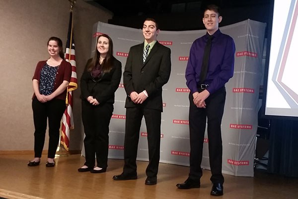 Honors business students on stage presenting at BAE Systems