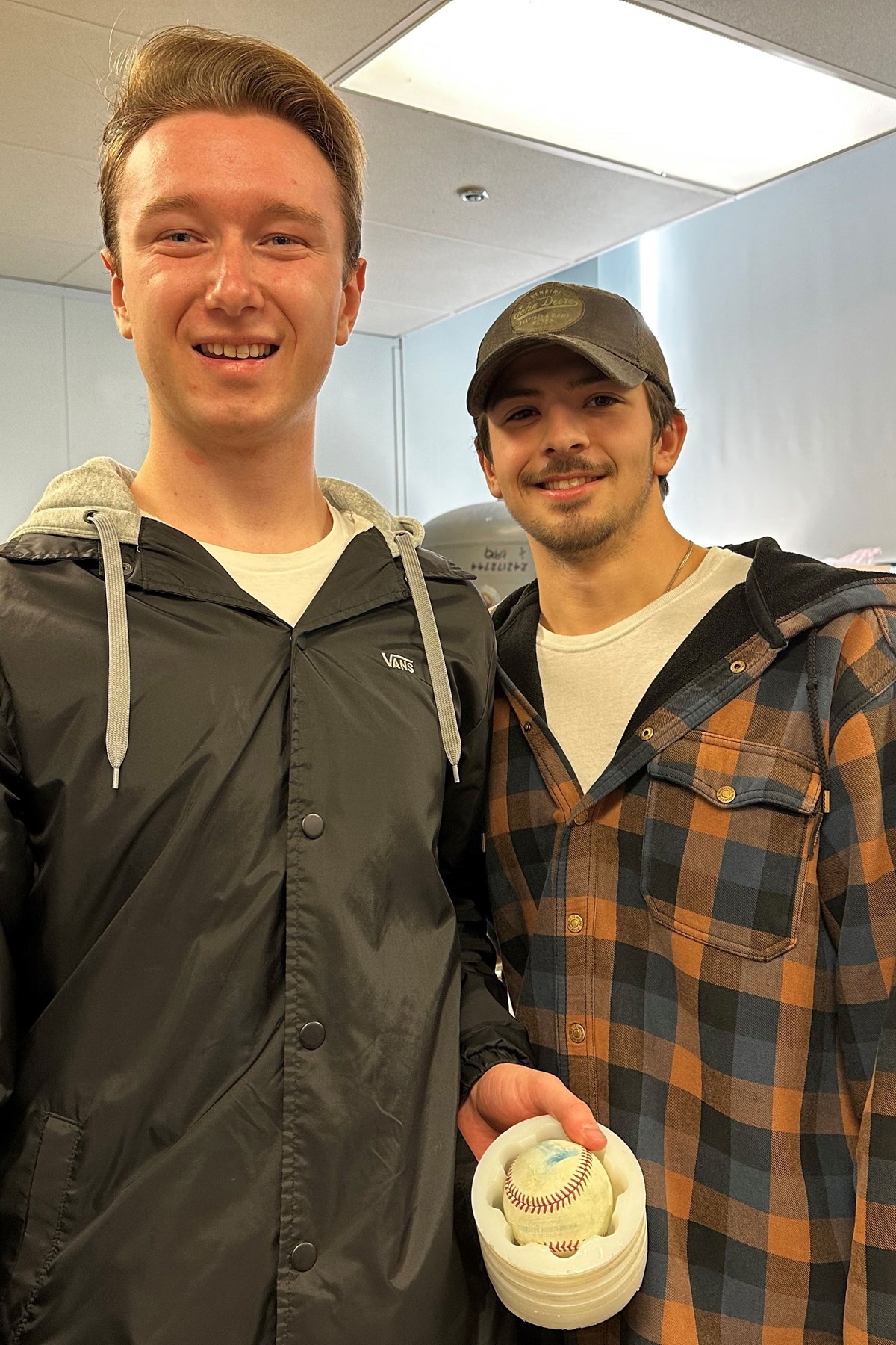 Mechanical engineering majors Ryan Donnelly and Kevin Clougherty standing together in class holding a baseball.