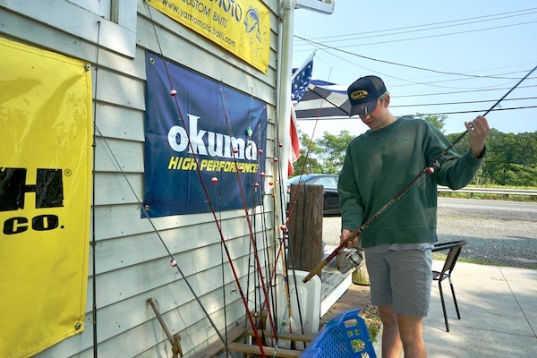 Ben Kenney sorts refurbished fishing rods that he gives to kids