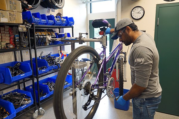 A student mechanic works on a bicycle