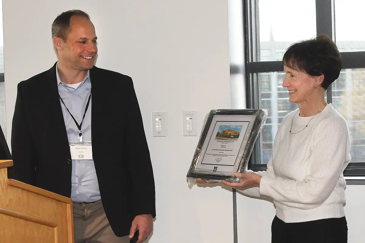 Brian Hess receives a framed certificate from Mary Ann Picard.