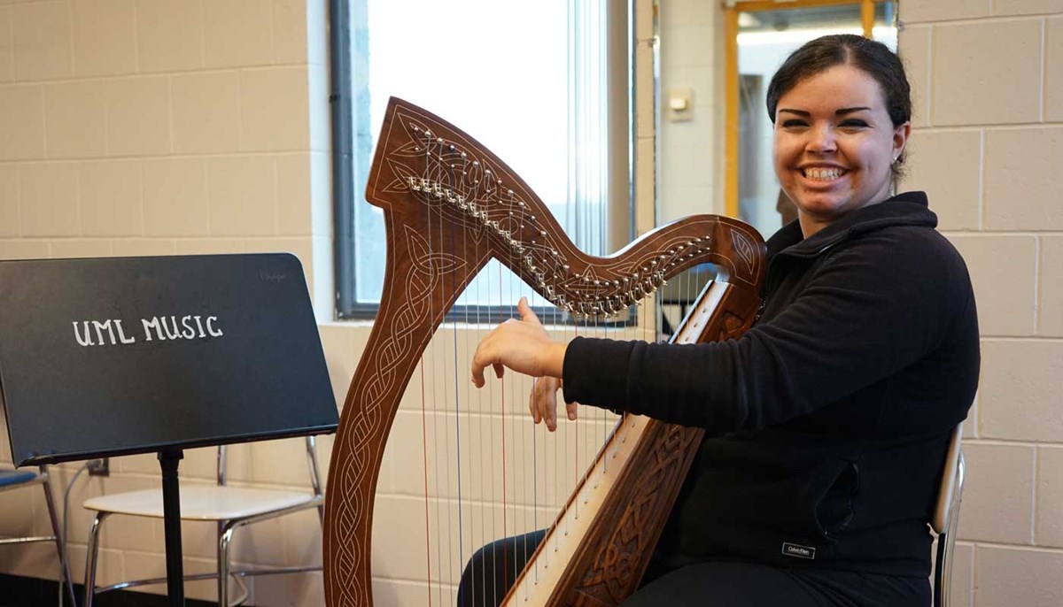 Music business major Brynne Santos plays the harp at UMass Lowell