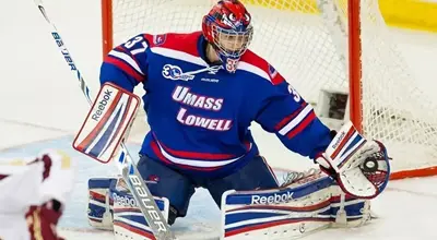 Ice hockey goalie sprawls to save a shot