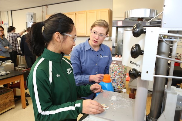 Meg Sobkowicz-Kline talks to a student about recycled plastics in the lab
