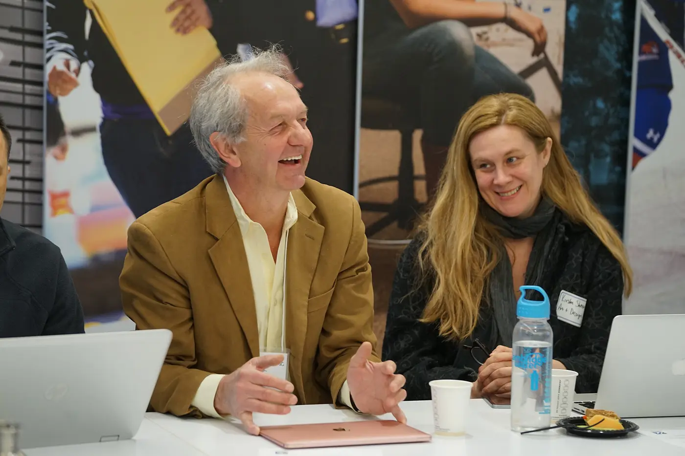 CCI Faculty in the political science and art departments sit side by side smiling while introducing themselves to MA State Legislators.