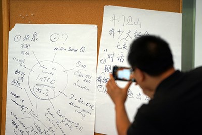 A workshop participant takes a photo of notes