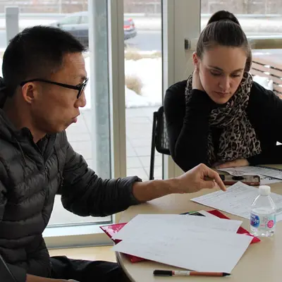 Man and woman sitting at table reviewing papers