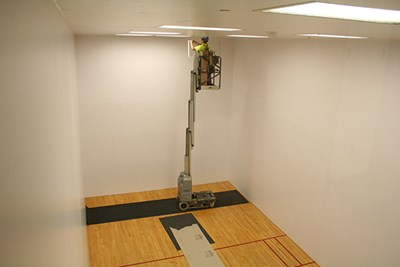A worker replaces lighting at the Campus Rec Center
